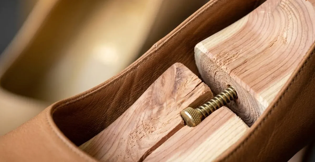 Close-up of cedar shoe trees inside luxury leather pumps showing gradual expansion technique