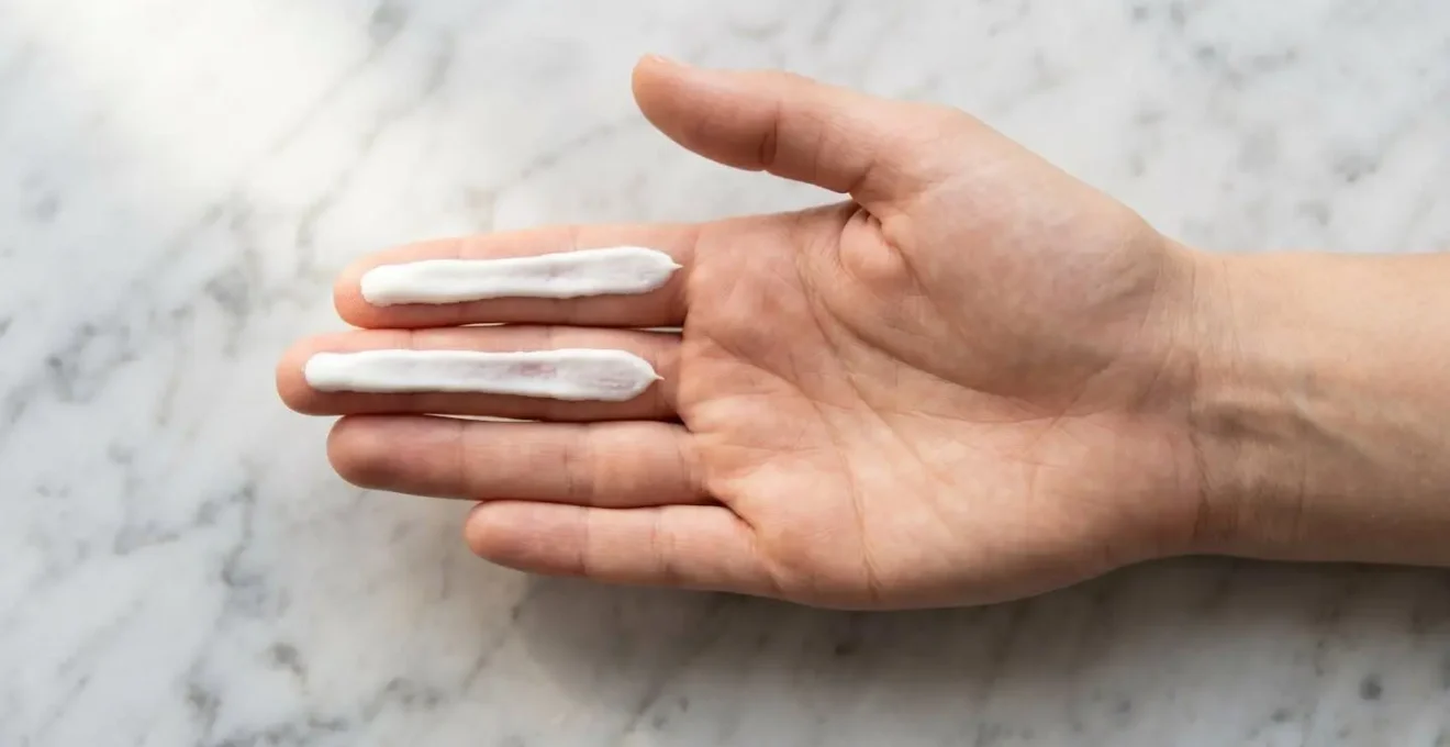 Hand demonstrating the two-finger measurement technique for sunscreen application